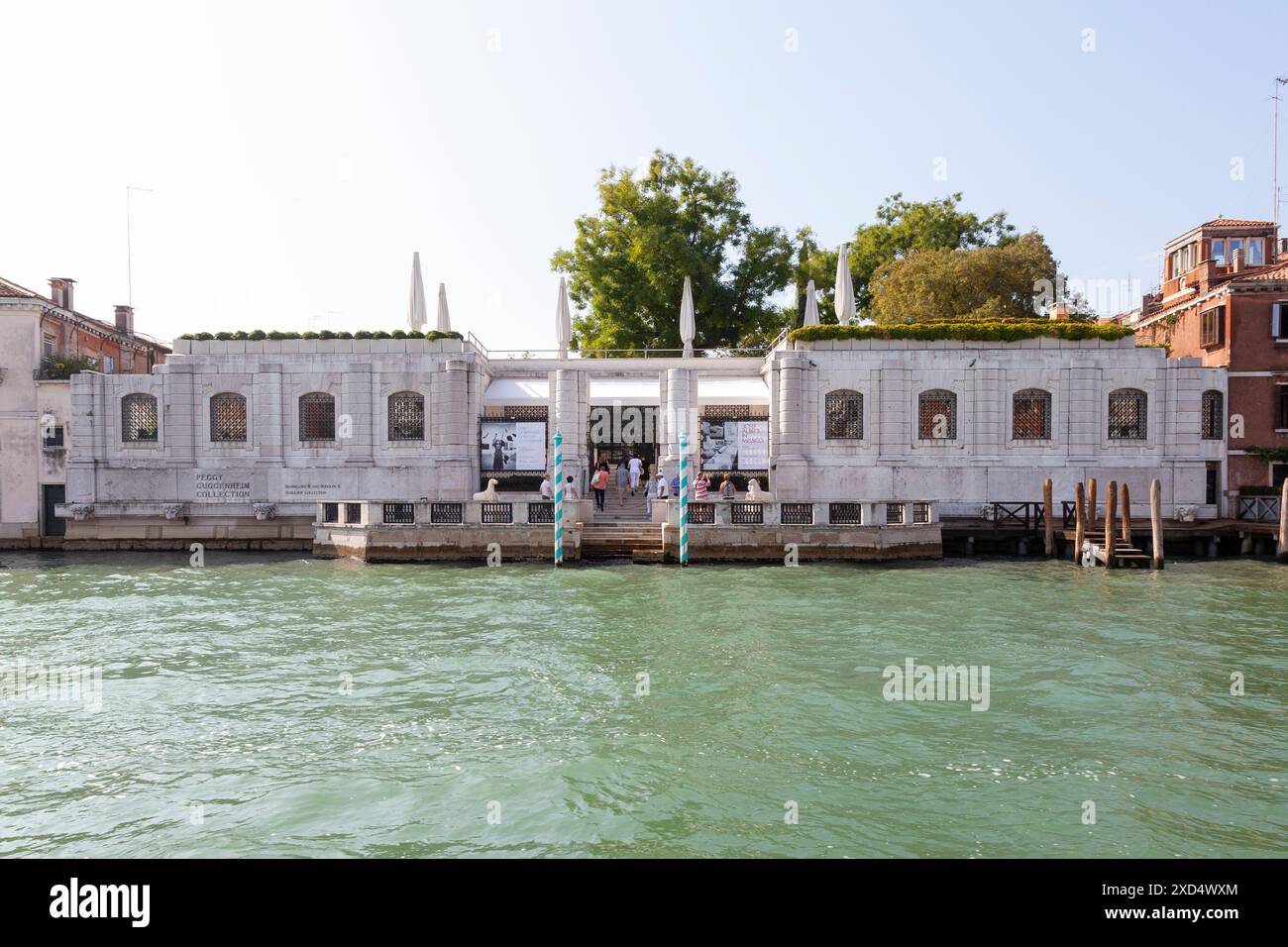 Fassade des Peggy Guggenheim Museums, Venedig, Italien vom Canal Grande bei Sonnenuntergang mit Touristen auf der Terrasse Stockfoto