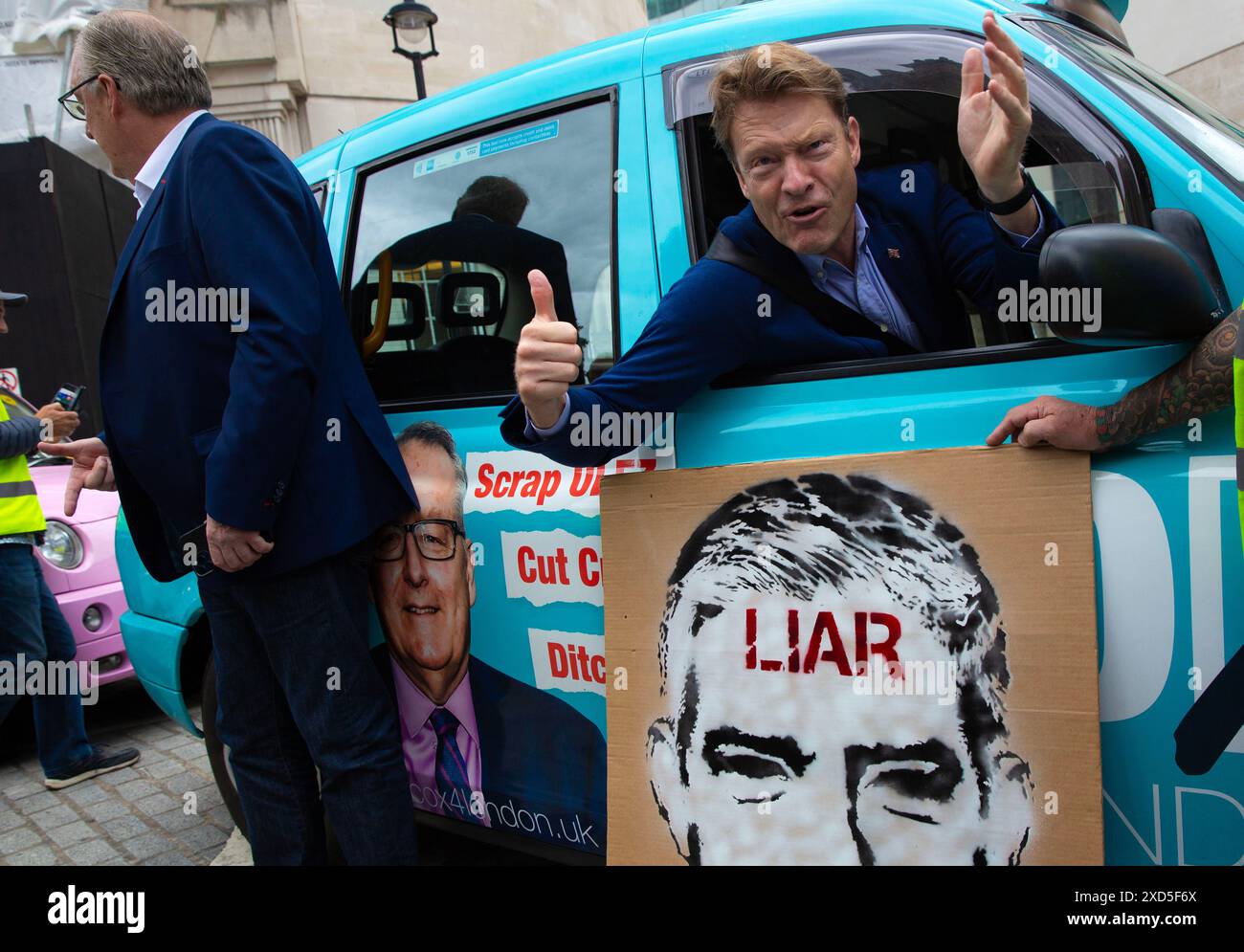 Die Teilnehmer versammeln sich während eines Protestes gegen die Erweiterung der ULEZ vor dem BBC Broadcasting House in London. Stockfoto