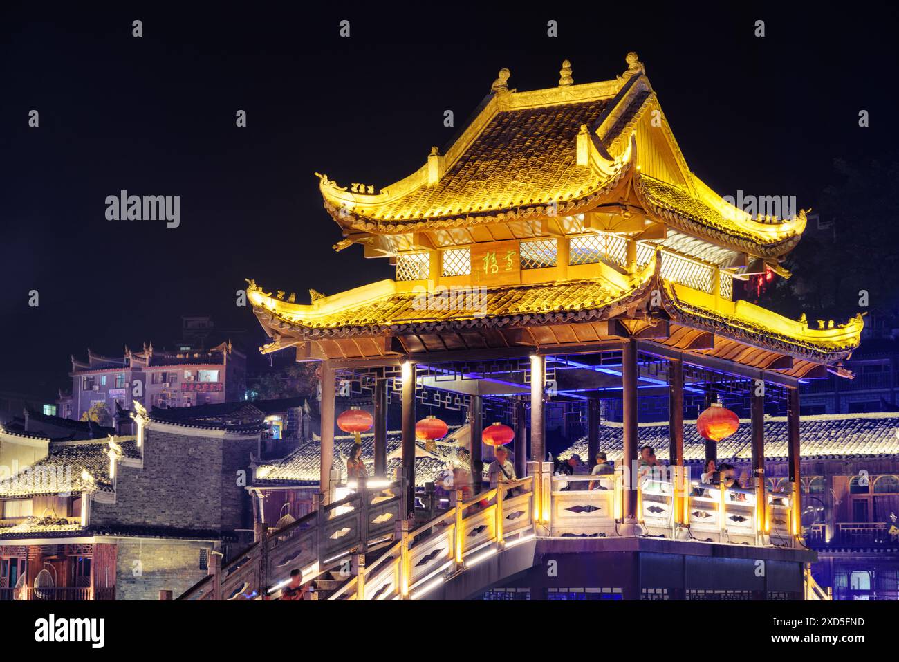 Fenghuang, China - 23. September 2017: Fabelhafter Blick auf die Brücke bei Nacht mit Elementen traditioneller chinesischer Architektur in der antiken Stadt Phoenix. Stockfoto