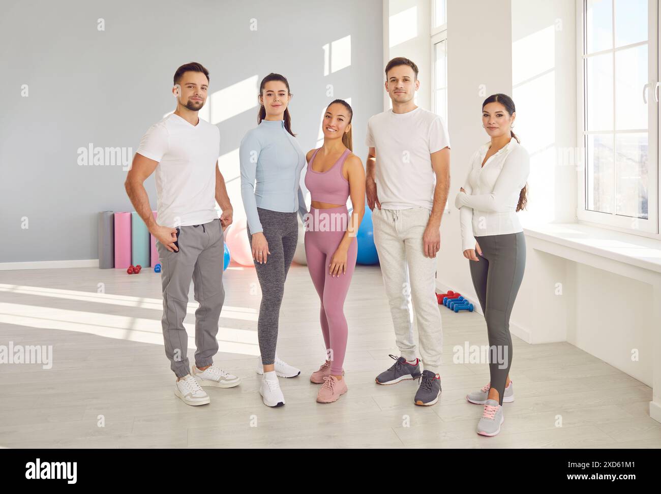 Sportlich fröhliche Menschen und Coach Porträt, persönliches Training in kleiner Gruppe, individuelle Teamleistung Stockfoto