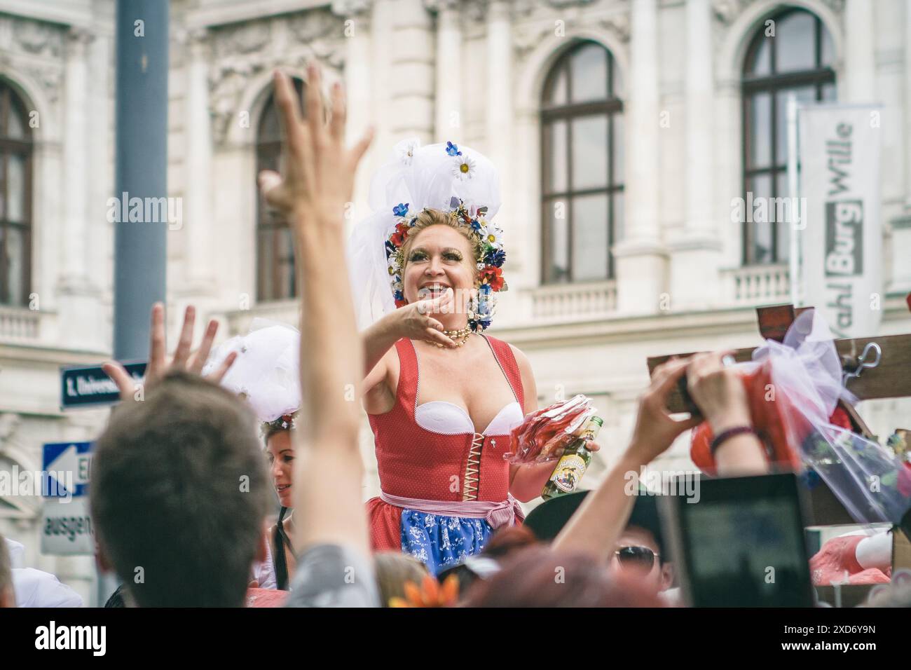 Verkleidet Frau in einem Dirndl und wirft Süßigkeiten in die Menge bei der Stolz-Parade Stockfoto