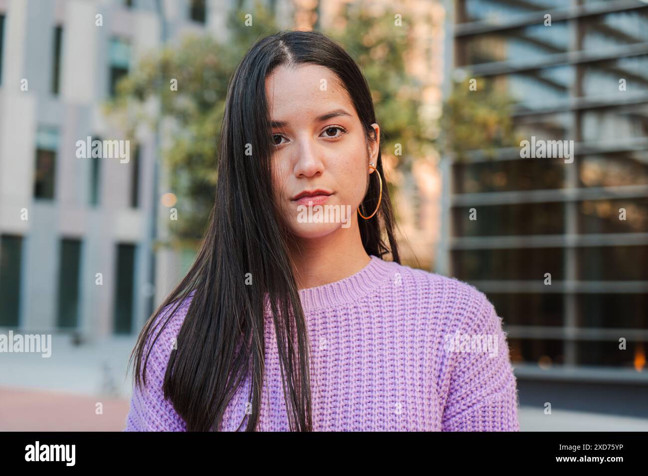Ein Porträt einer entschlossenen jungen Latina-Studentin, die allein draußen steht, mit einem reflektierenden Ausdruck nach vorne blickt, Vertrauen und Selbstbewusstsein ausstrahlt. Frau, die ernsthaft in die Kamera schaut. Hochwertige Fotos Stockfoto