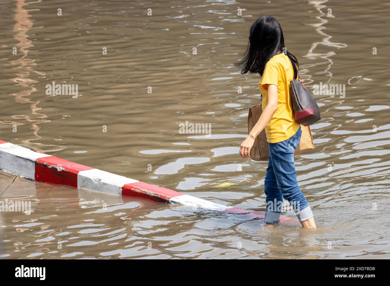 Eine Frau läuft auf einer überfluteten Straße, Bangkok, Thailand Stockfoto