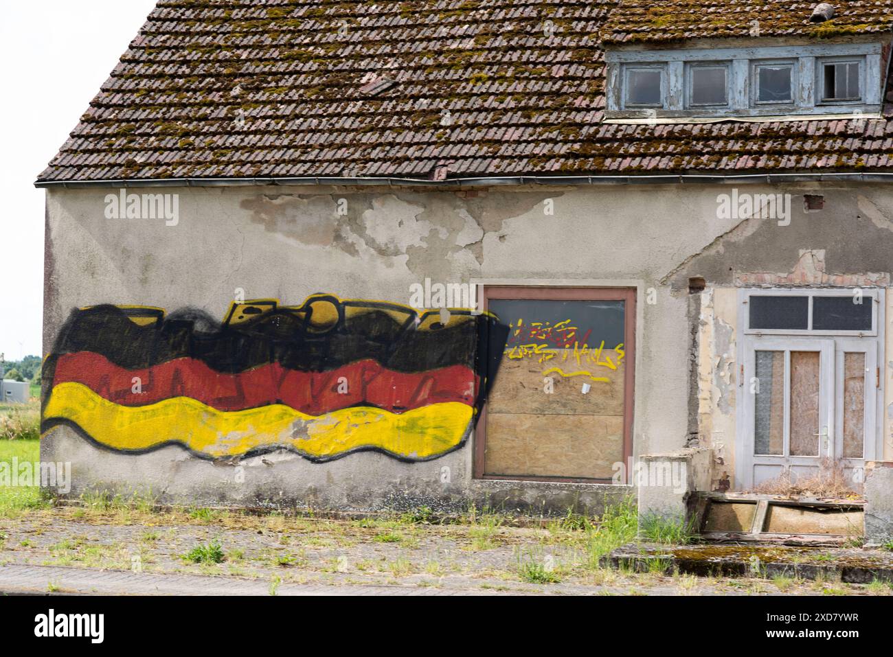 Eine Hausruine mit einer angemalten Deutschlandfahne an der Fassade steht an einer Bundesstraße in Vorpommern. Anklam *** Eine Ruine mit gemalter deutscher Flagge an der Fassade steht an einer Hauptstraße in Anklam, Vorpommern Copyright: FrankxHormannx/xnordlicht Stockfoto