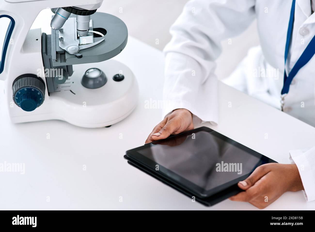Forschung, Tablette und Hände im Labor für Wissenschaft, Medizin und Mikroskop für Biotechnologie. Person, Wissenschaftler und Technologie am Tisch für Kommunikation Stockfoto