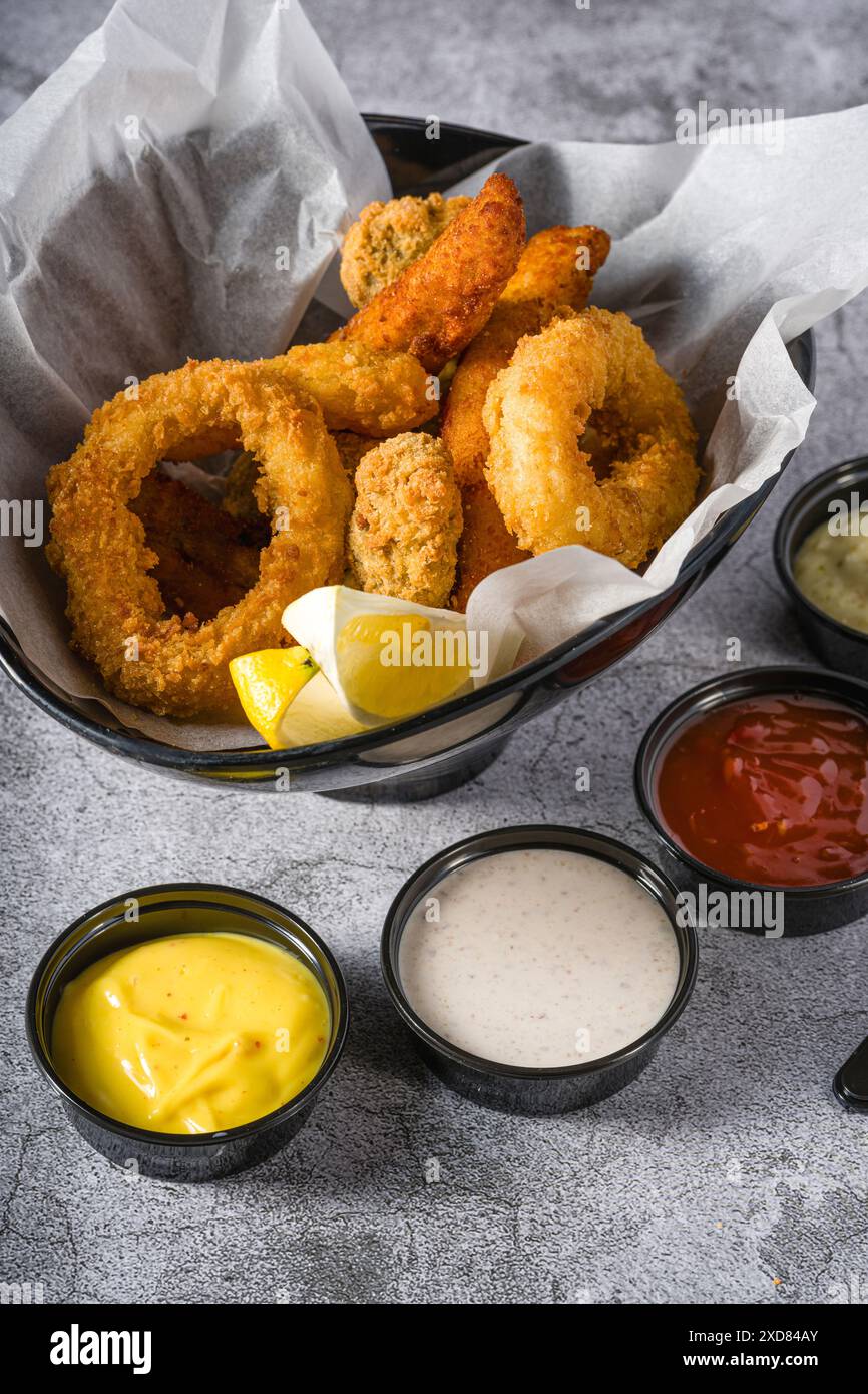 Frittierte Tintenfische, Garnelen und Muscheln mit Saucen an der Seite Stockfoto