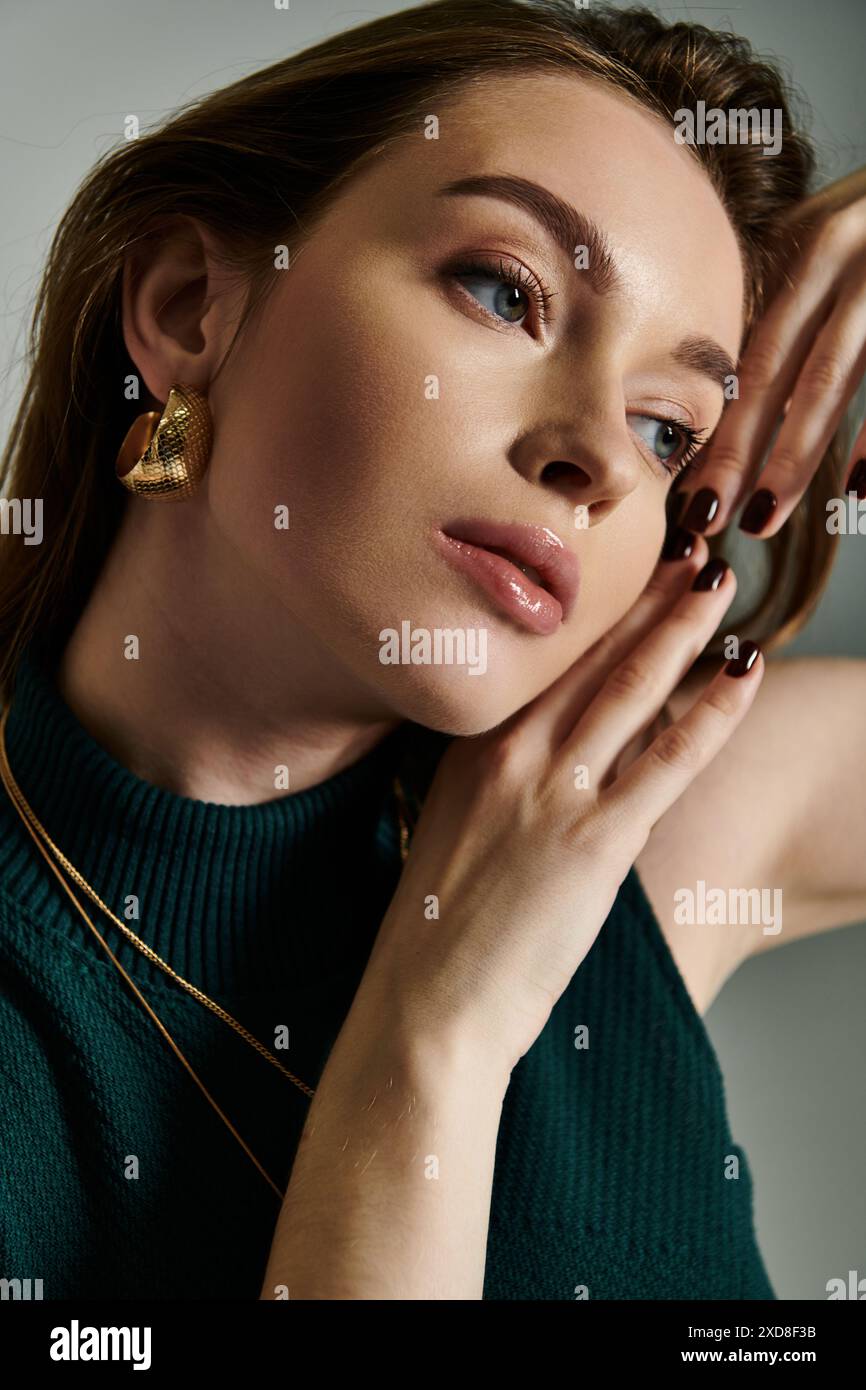 Eine junge Frau hält ihre Hände zärtlich an ihr Gesicht in einem Moment des Denkens und der Reflexion. Stockfoto