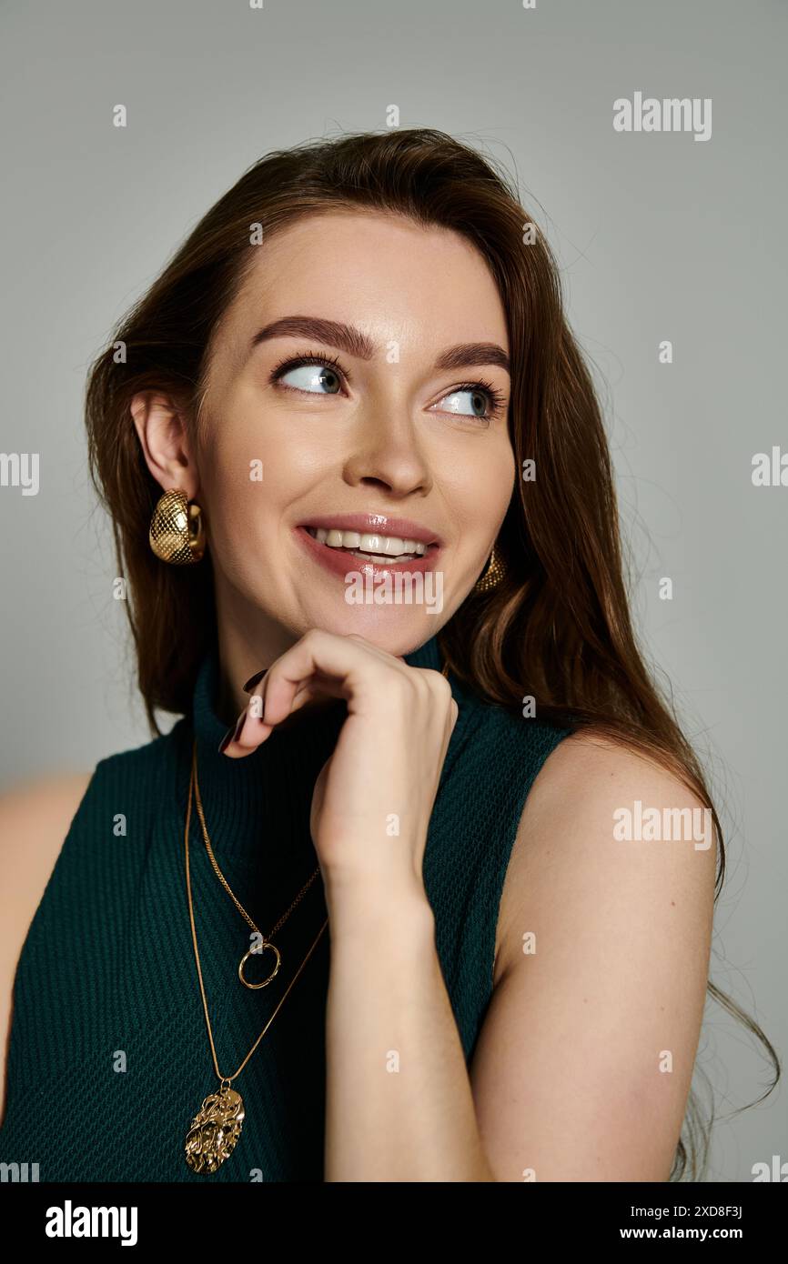 Eine stilvolle Frau in einem leuchtend grünen Oberteil posiert elegant für ein Modeshooting. Stockfoto