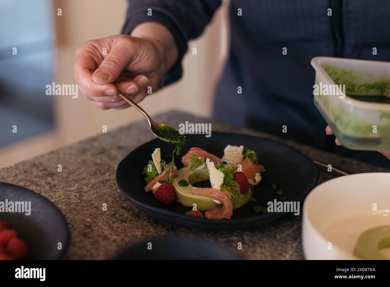 Küchenchef serviert ein Gourmetgericht mit frischen Zutaten und Beilagen Stockfoto
