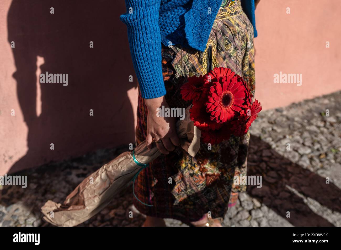 Frau, die rote Blumen in der Hand hält Stockfoto