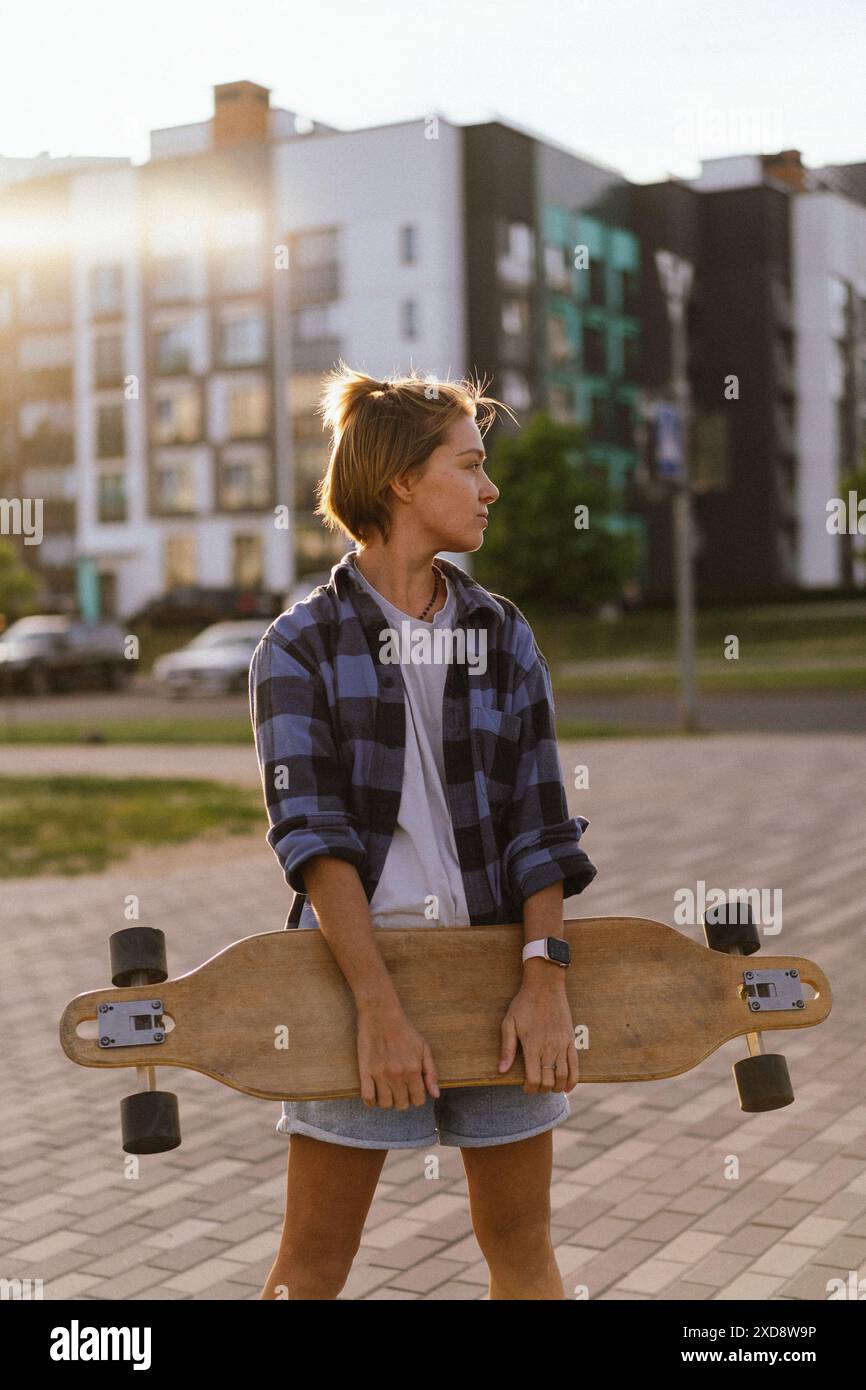 Junge Frau mit Skateboard in der Stadt. Stockfoto