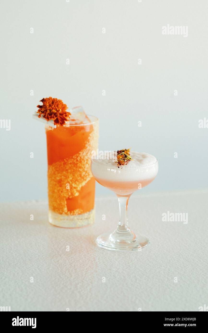 Zwei bunte Cocktails mit Blumen. Stockfoto