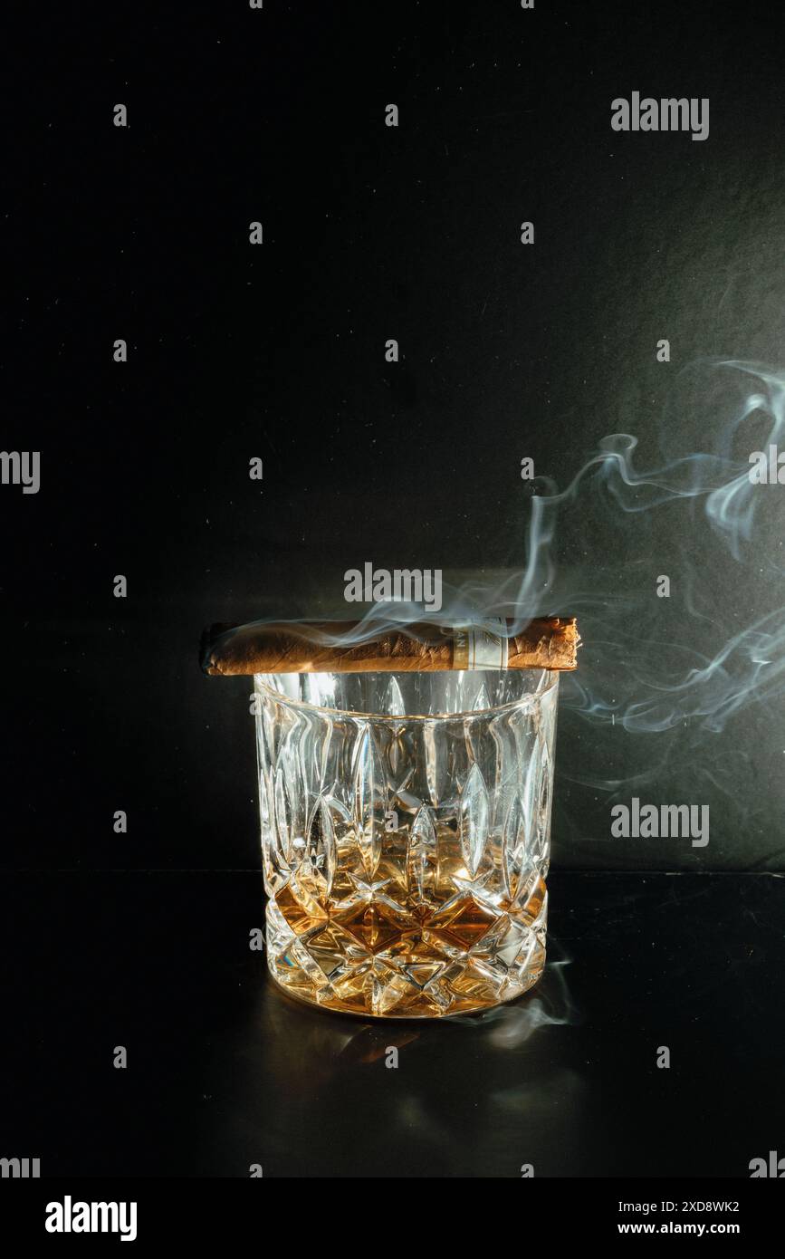 Rocks Glas Whiskey mit einer rauchenden Zigarre Stockfoto