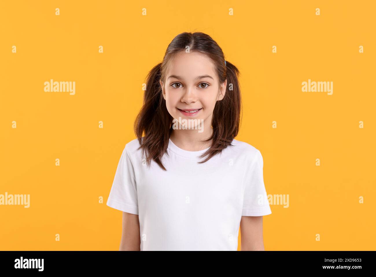 Porträt eines schönen Mädchens auf orangefarbenem Hintergrund Stockfoto