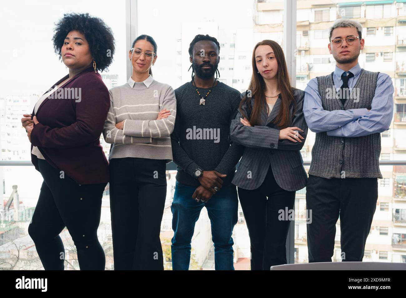 Firmenporträt des Arbeitsteams im Co-Working, Gruppe ernster Geschäftsleute unterschiedlicher Ethnien, die im Büro mit dem Fenster stehen Stockfoto