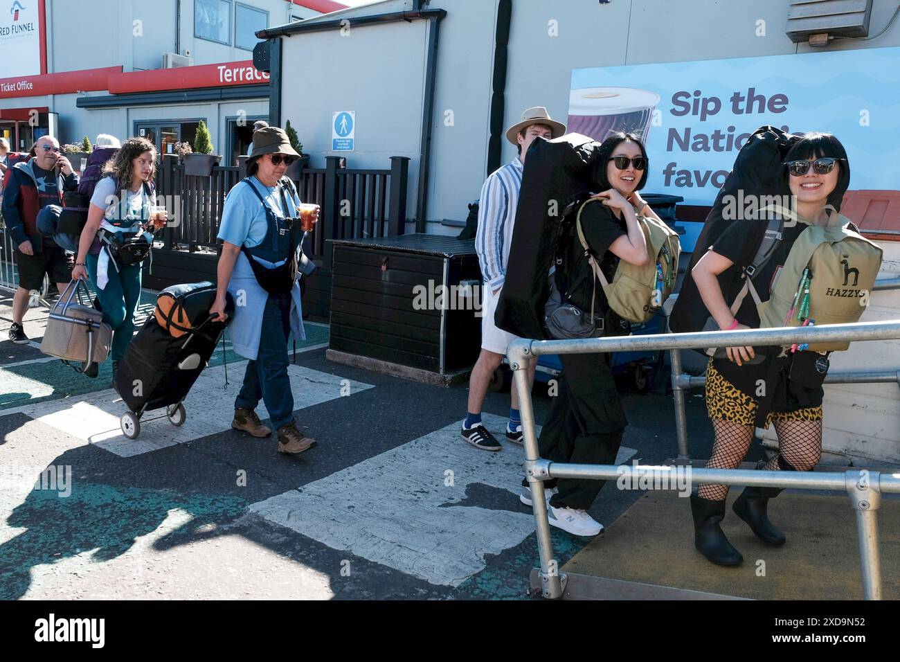 Southampton, Hampshire, Großbritannien, 20. Juni 2024. Massen von Festivalbesuchern mit Rucksäcken, Trollien und Zelten warten auf eine Fahrt mit der Red Funnel Fähre zum Isle of Wight Festival am 20. Juni 2024. Stockfoto