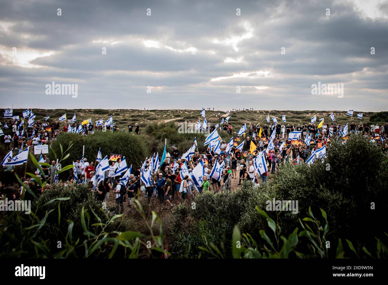 Israelische Demonstranten schwenken ihre Nationalflagge während einer Protestkundgebung an der Seite des israelischen Ministerpräsidenten Benjamin NetanyahuÕs in Caesarea und rufen ihn zum Rücktritt auf. Donnerstag, 20. Juni 2024. Netanjahu hat wiederholt gesagt, dass keine Wahlen stattfinden sollten, solange der Krieg in Gaza noch andauert. Die nächsten Parlamentswahlen sind offiziell für Oktober 2026 geplant. Foto: Eyal Warshavsky./Alamy Live News Stockfoto