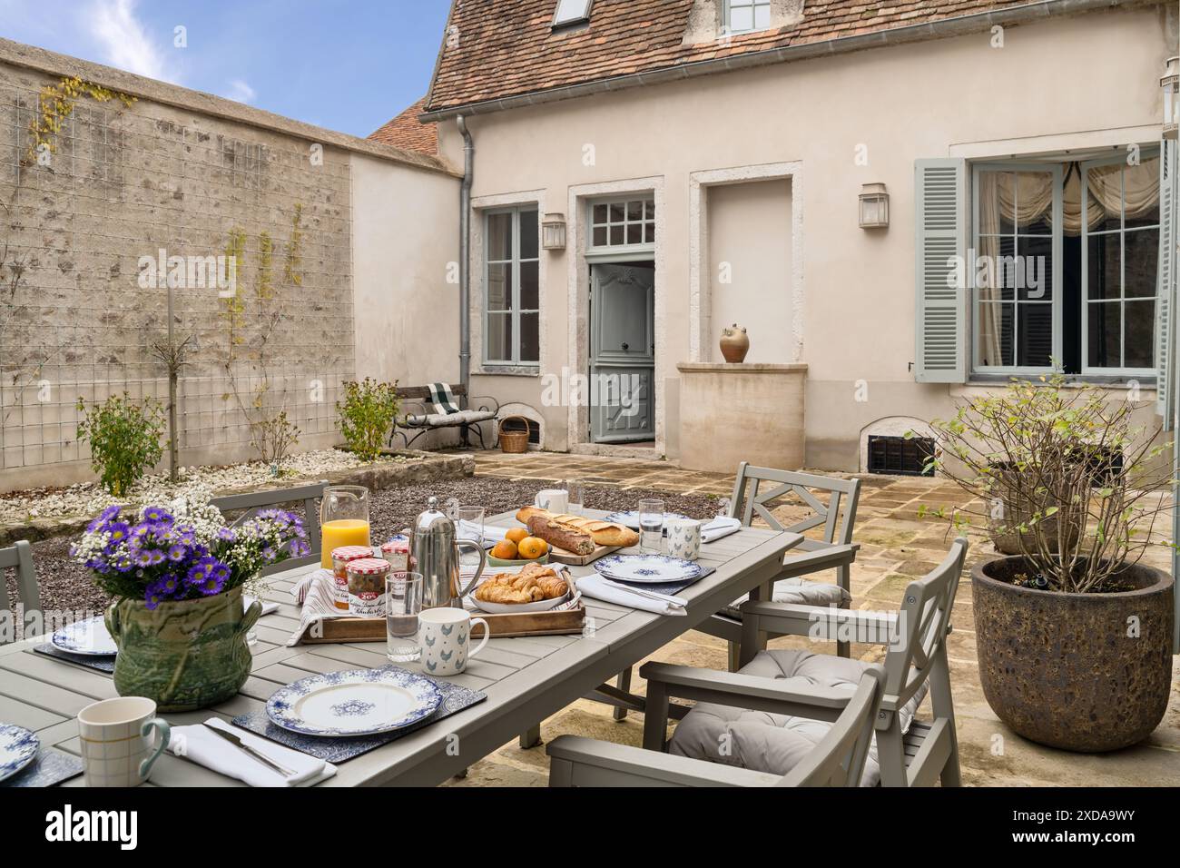 Frühstück im Innenhof eines renovierten, aus Stein gebauten Hotels, das aus dem Jahr 1770 in Saulieu, Burgund, Frankreich stammt. Stockfoto