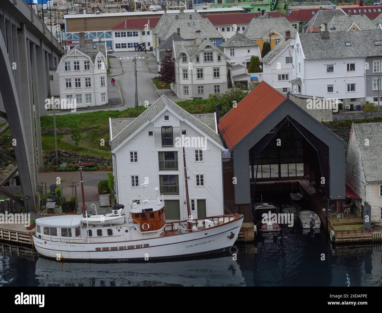 Hafen mit Fischerbooten und Häusern in einer kleinen Stadt unter einer großen Brücke, haugesund, norwegen Stockfoto