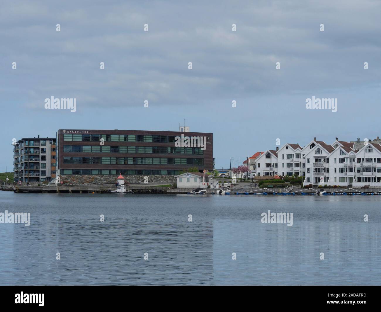 Blick auf den Hafen mit modernen Apartmentgebäuden und traditioneller Architektur am ruhigen Wasser, haugesund, norwegen Stockfoto