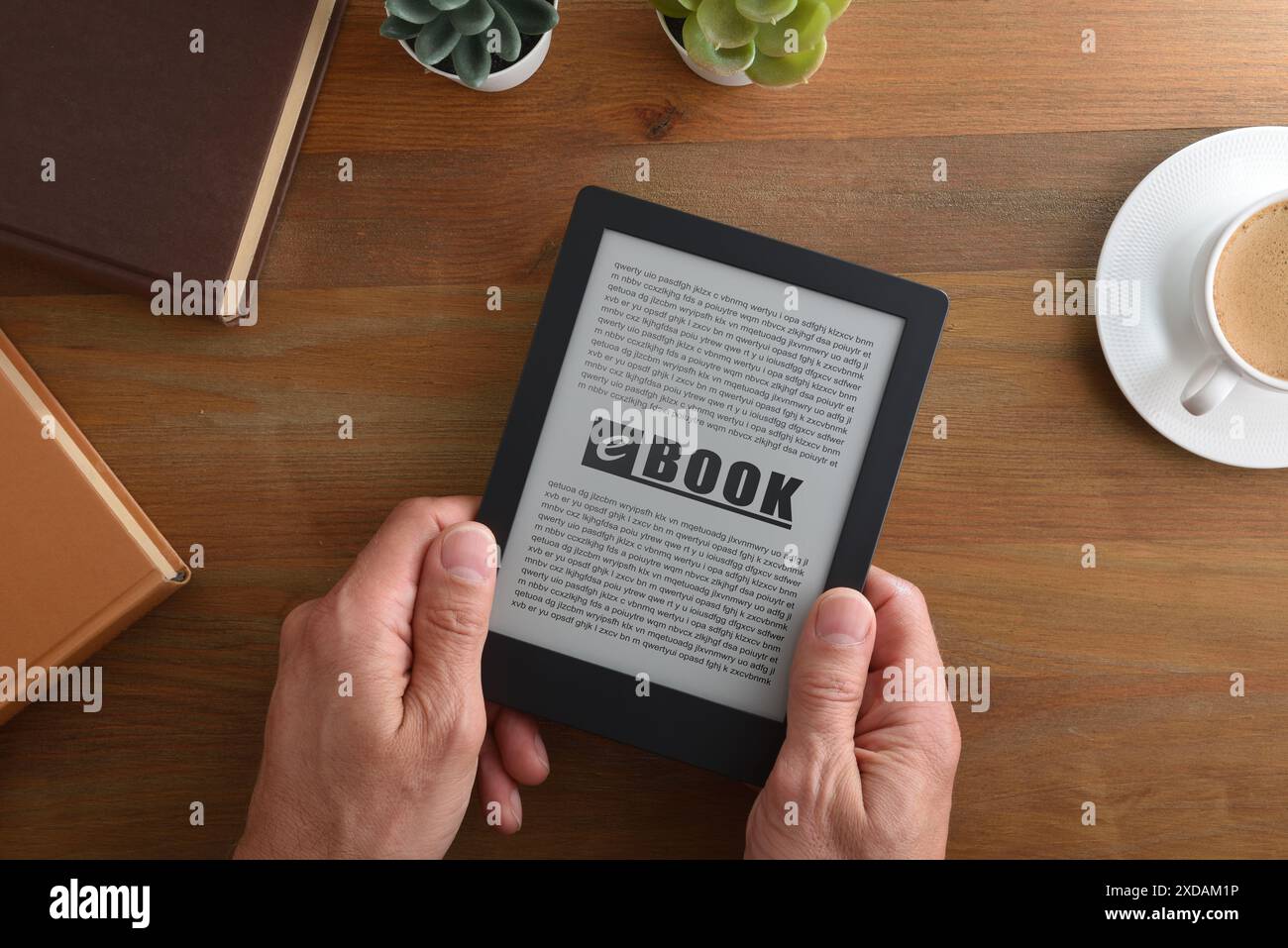 Die Person, die ein eBook liest, hat sich bei einem Kaffee auf einem Holztisch zu Hause entspannt. Draufsicht Stockfoto