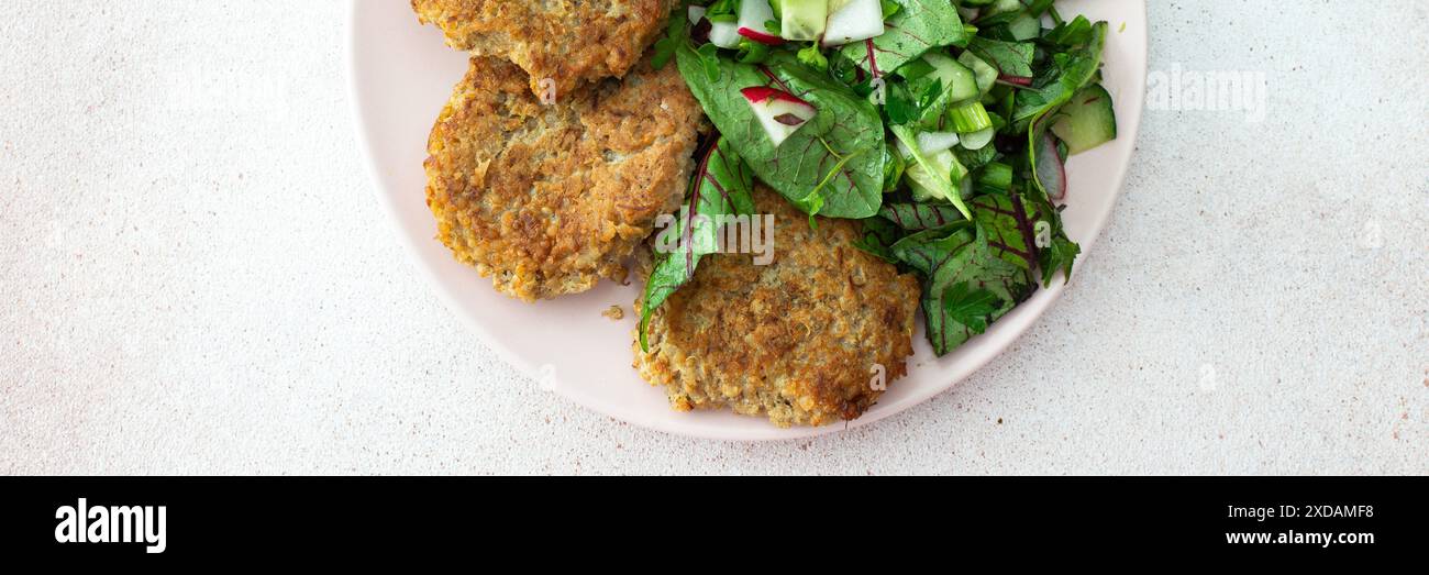 Quinoa Schnitzel und gemischter Salat mit Avocado und Radieschen, Kiwi und Wasser mit Zitrone, köstliches herzhaftes Frühstück, veganes Lunch Teller Banner Stockfoto