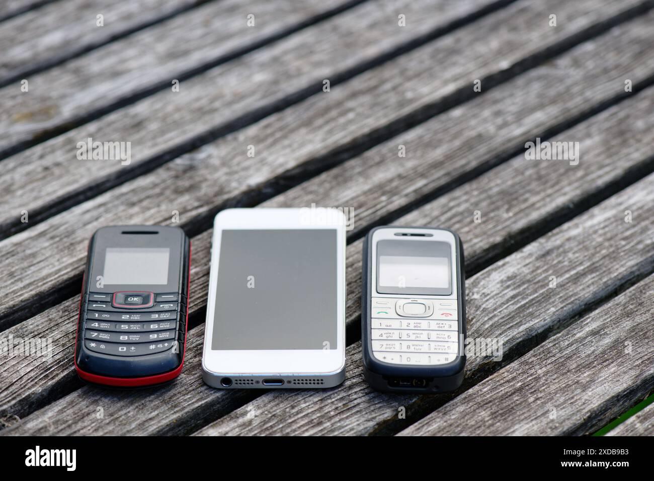 Alte Handys auf einem alten verwitterten Holztisch Stockfoto