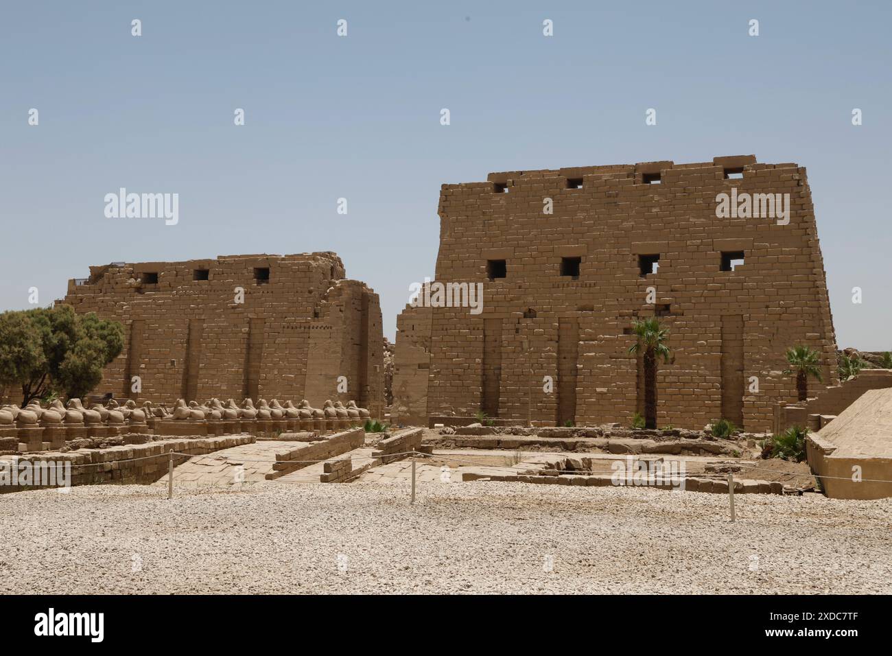 Der Tempel von Amun-Re (auch bekannt als Amun-Ra) in Karnak Ägypten und die Avenue der Rams, die von Touristen in der intensiven Mittagshitze eines Junitages verlassen wurden. Stockfoto