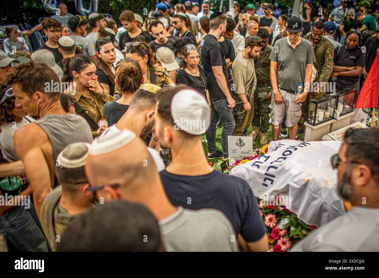 Die Trauernden versammeln sich um das Grab des gefallenen Soldaten Omer Smadga während seiner Begräbniszeremonie auf dem Militärfriedhof in Netanya. Smadga starb am Donnerstag im Kampf gegen die Hamas im Gazastreifen. Sein Vater, Oren, sprach über sein Grab und rief die IDF auf, so hart wie möglich zu kämpfen. Mach so hart wie möglich weiter. Hör nicht auf, bis wir gewonnen haben. Das ist meine Botschaft an jeden, der im Kampf ist. Am Israel Hai. Oren Smadga ist der israelische Judo-Medaillengewinner der Olympischen Spiele 1992 in Barcelona und aktueller Trainer des israelischen Judo-Teams. Stockfoto