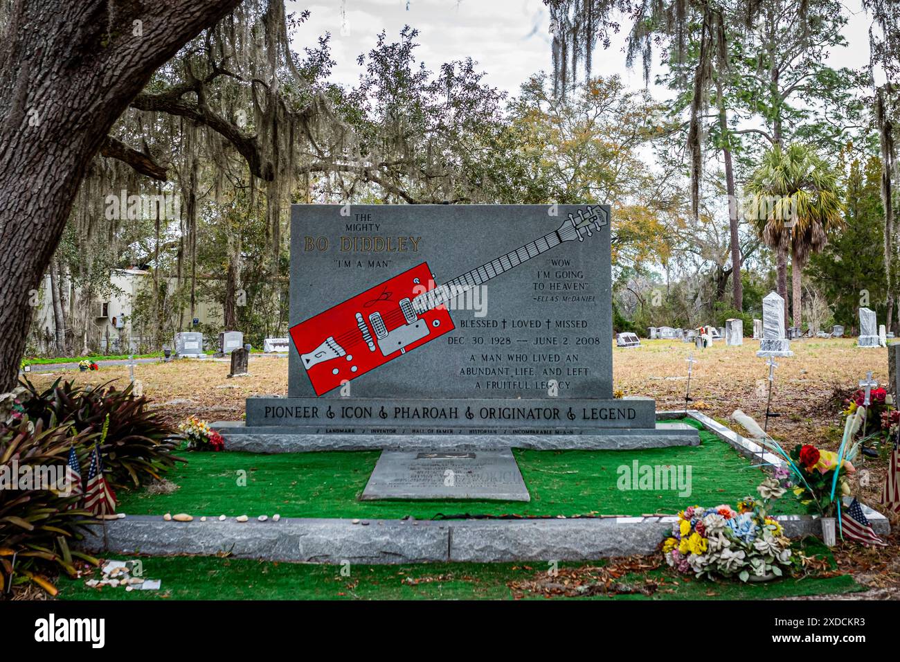 Bronson, FL, USA - 15. Februar 2024: Grab des berühmten und verehrten Musikers Bo Diddley auf einem ruhigen Friedhof unter einer großen Eiche mit Moos. Blumen Stockfoto