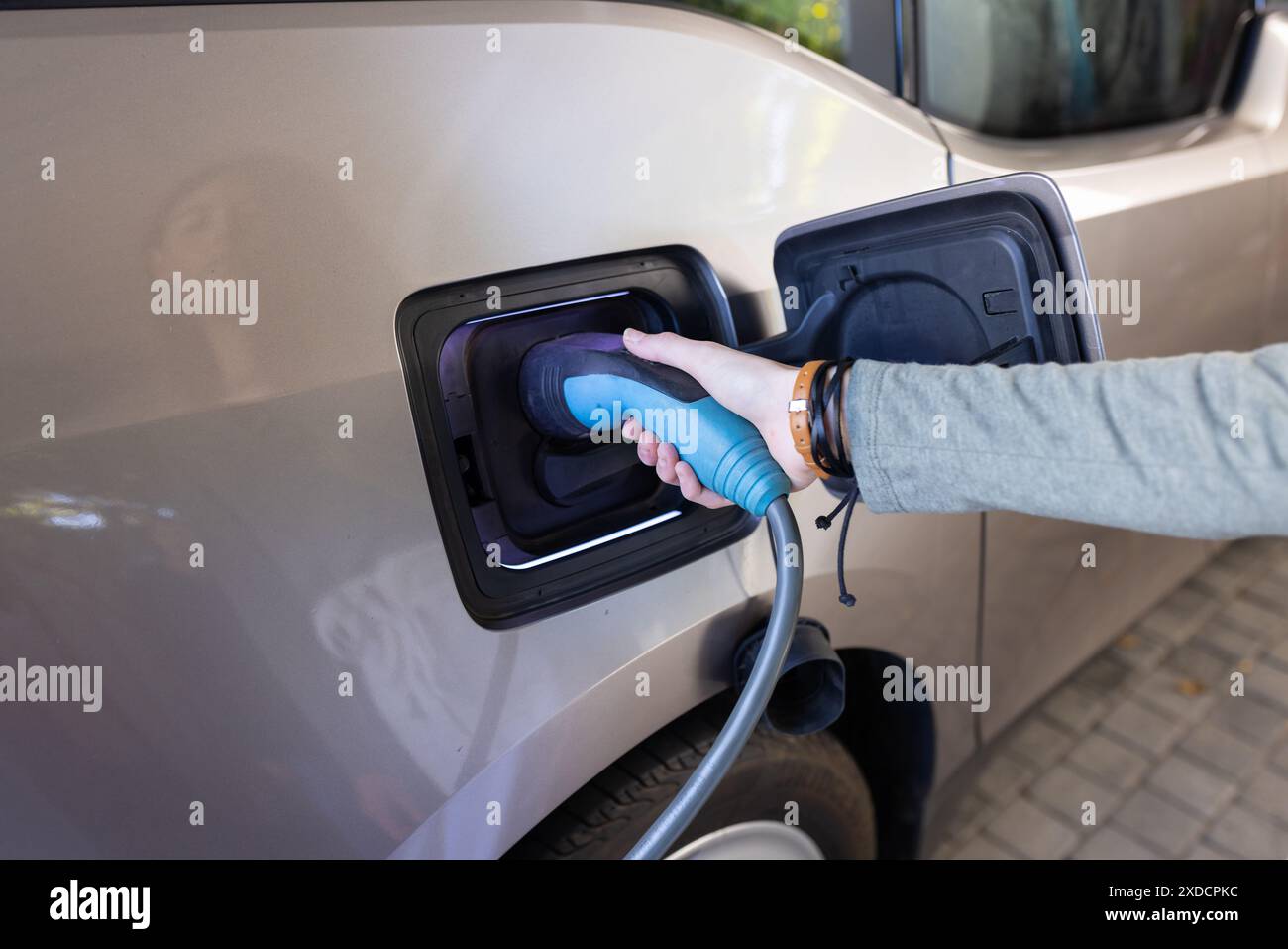 Laden des Elektroautos, Handsteckerbuchse und Anschluss an das Fahrzeug Stockfoto
