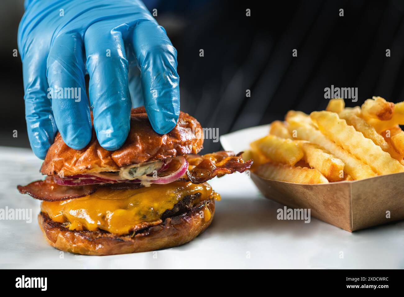 Cheeseburger mit Speck und Pommes frites. Stockfoto