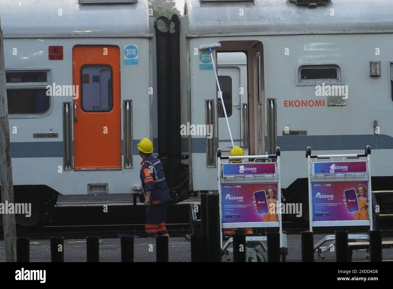 Arbeiter an einem Bahnhof in Indonesien, die morgens die Karosserie reinigen Stockfoto