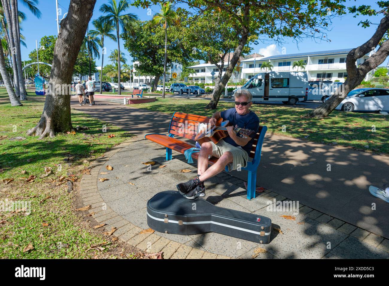 Lächelnder Senior-Mann, der Gitarre spielt in Strand Park, Townsville, Far North Queensland, FNQ, QLD, Australien Stockfoto