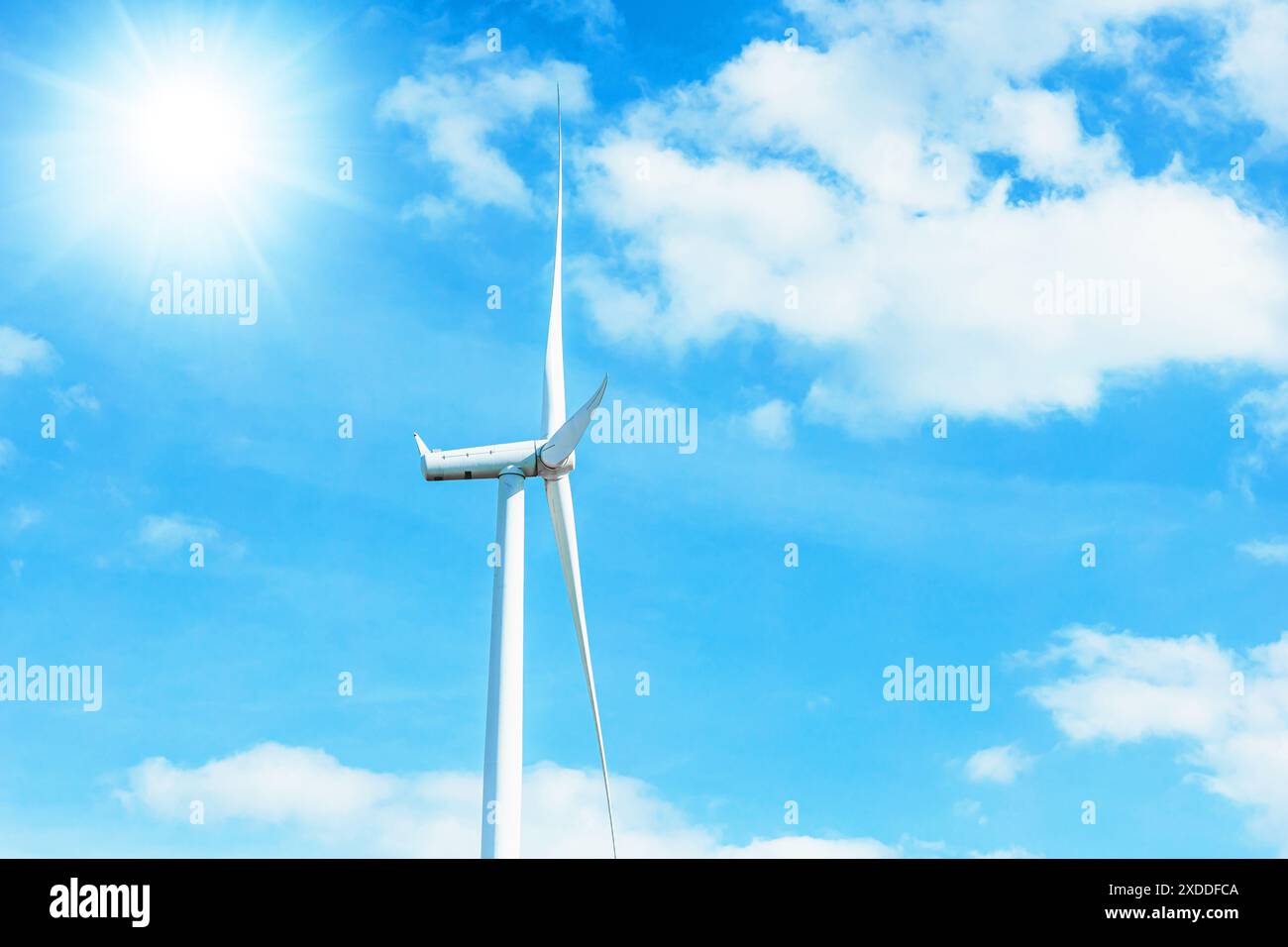 Windkraftanlage sauberer Strom Stromerzeuger auf blauem sonnigem Sommerhimmel Hintergrund Stockfoto