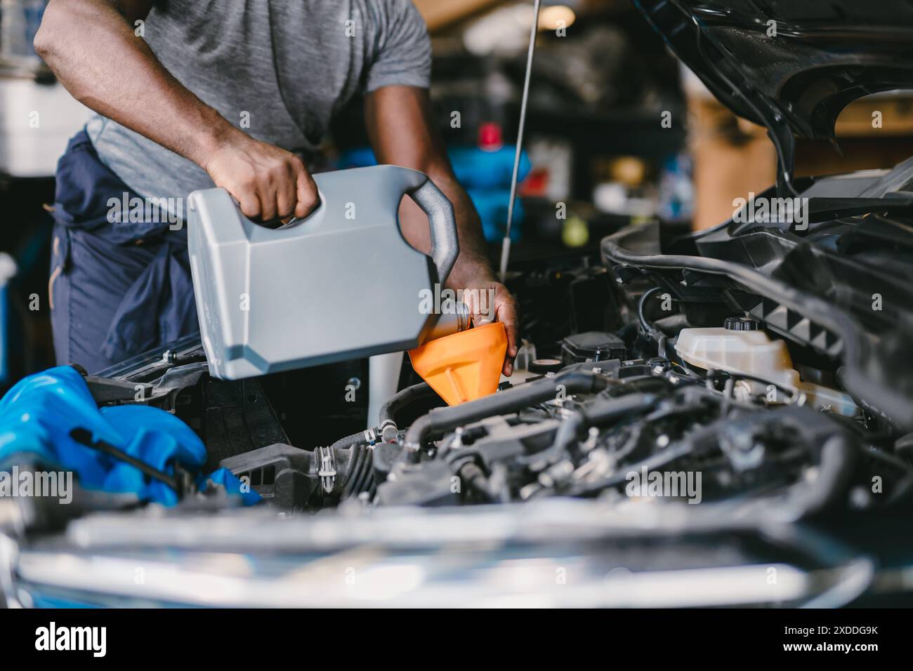 Closeup Garagenmechaniker professionell arbeitendes Auto Auto Auto Service Motoröl füllen. Stockfoto