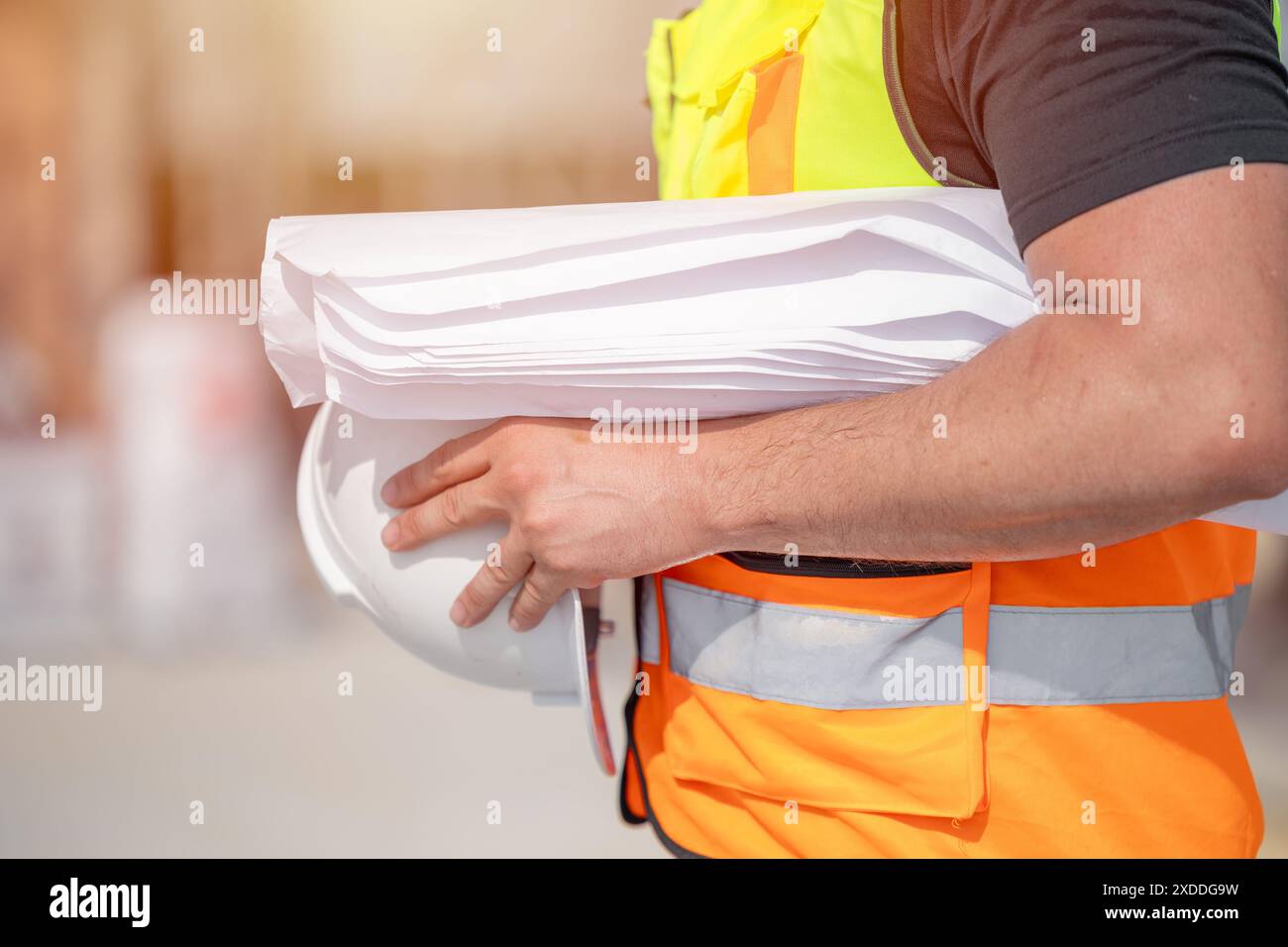 Closeup Ingenieur Bauarbeiter mit Blueprint und Schutzhelm auf der Baustelle Stockfoto