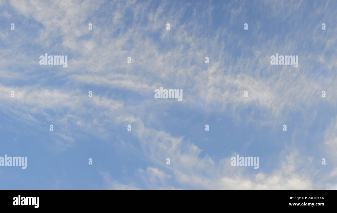 Klarer blauer Himmel mit dünnen, schimmernden weißen Wolken, die wie Pinselstriche über den Himmel aussehen. Stockfoto