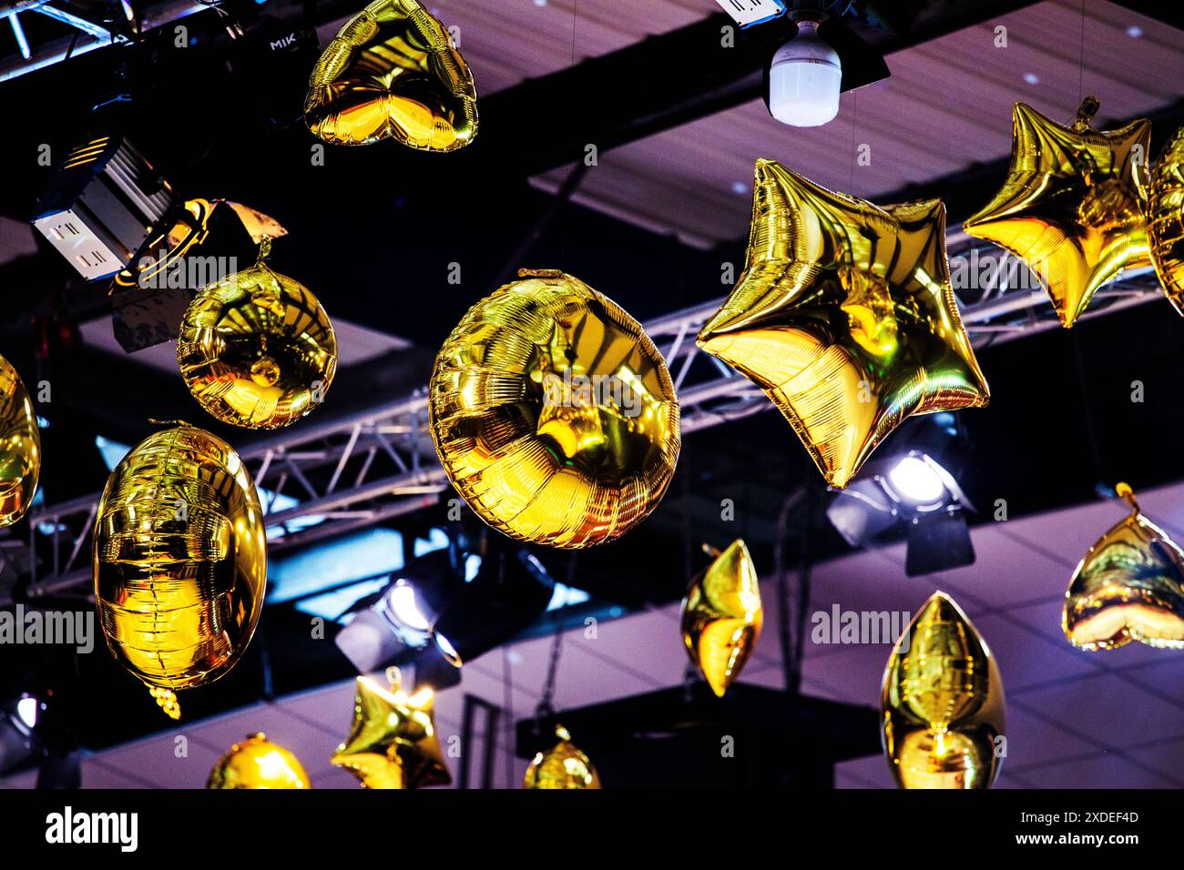 Aufblasbare, goldglänzende Kugeln und Sterne an der Decke. Festliche Innenausstattung Stockfoto