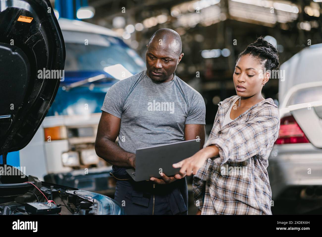 Garagenmechaniker afrikanischer schwarzer Mann, professioneller Autoservice, der Motoröl prüft Stockfoto