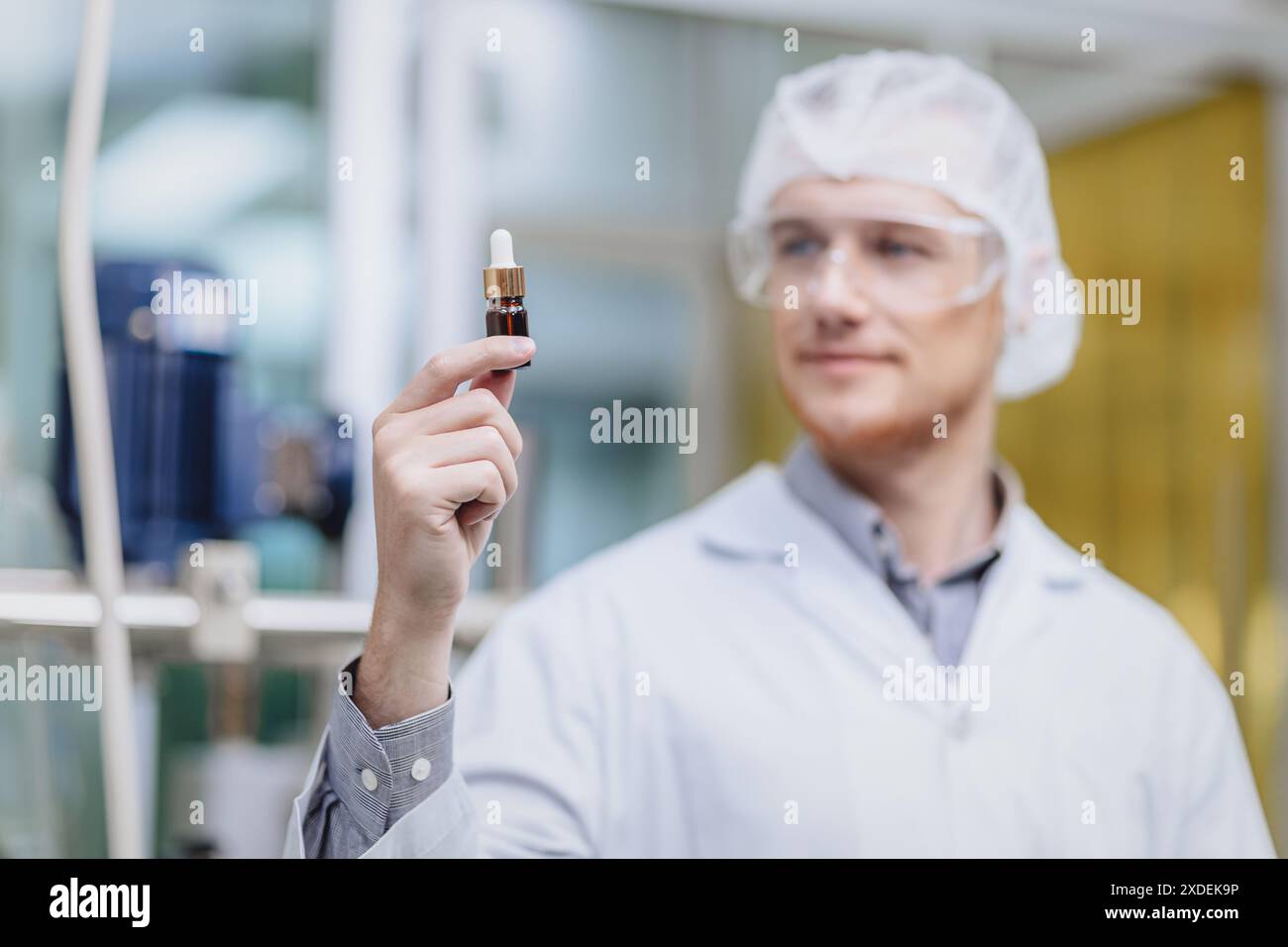 Wissenschaftler im Science Lab erfand stolz die neue Medizin-Formel. Medizinisches Fabrikpersonal glücklich lächelnd mit Konzentrat medizinischem Extrakt aus der Pflanze. Stockfoto
