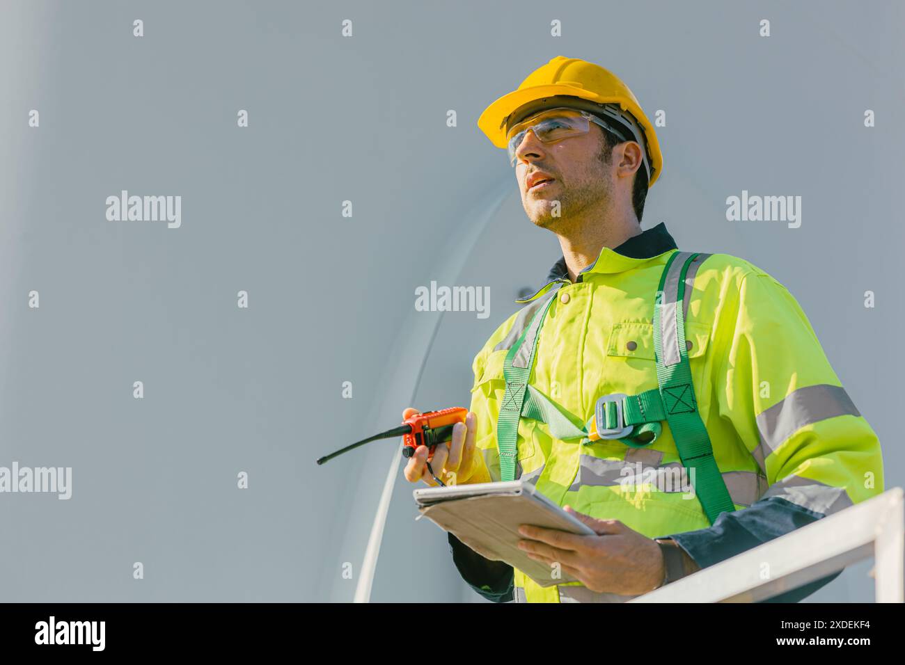 Professioneller Ingenieur männlich, der im Freien mit Sicherheit an Windturbinen arbeitet sauberer Energie Kraftwerk Hintergrund, Arbeiter Menschen mit erneuerbarer Energie tec Stockfoto