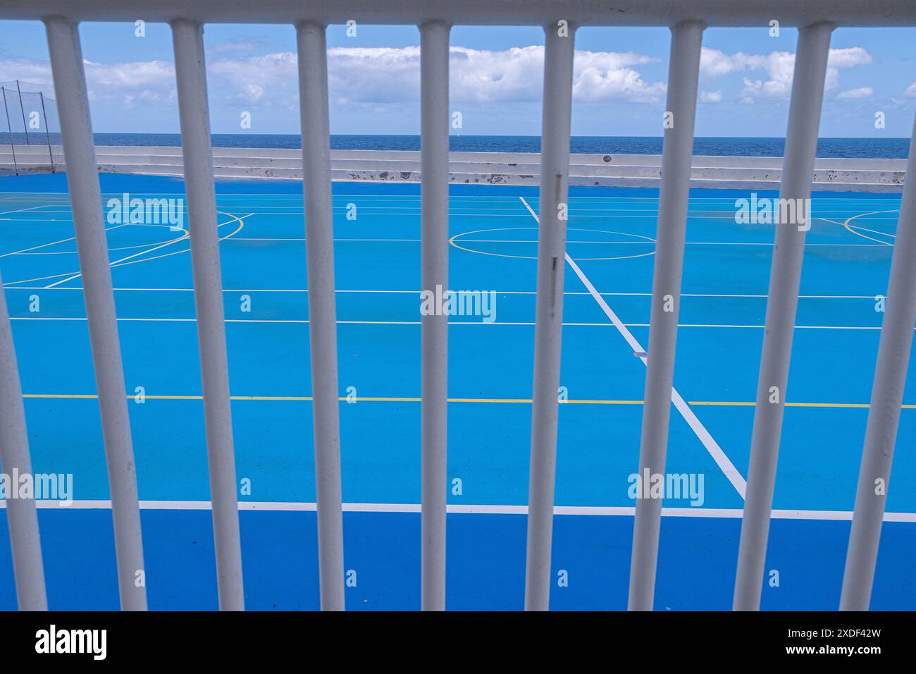 Teilweiser Blick von außen durch einige Bars eines Futsal-Feldes am Meer Stockfoto