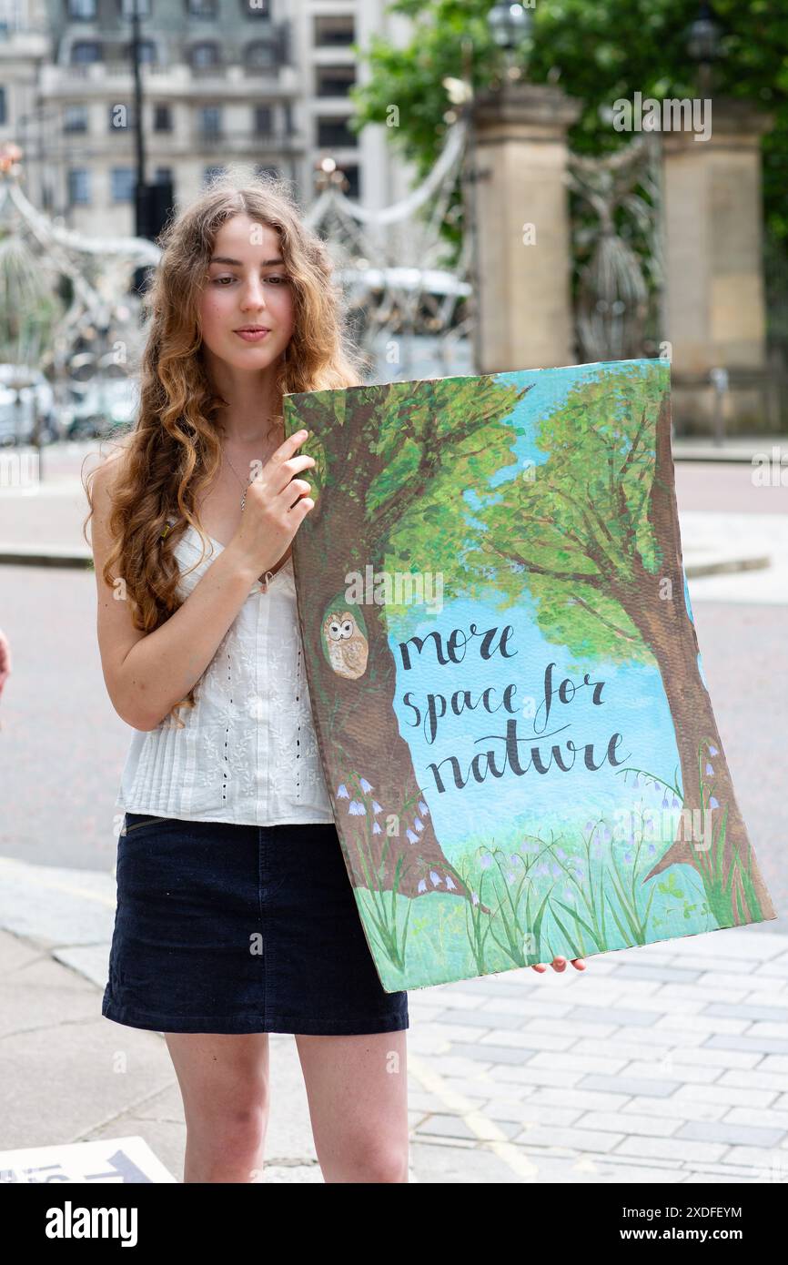 Junge Frau mit einem Plakat mehr Platz für die Natur in London, Großbritannien Stockfoto