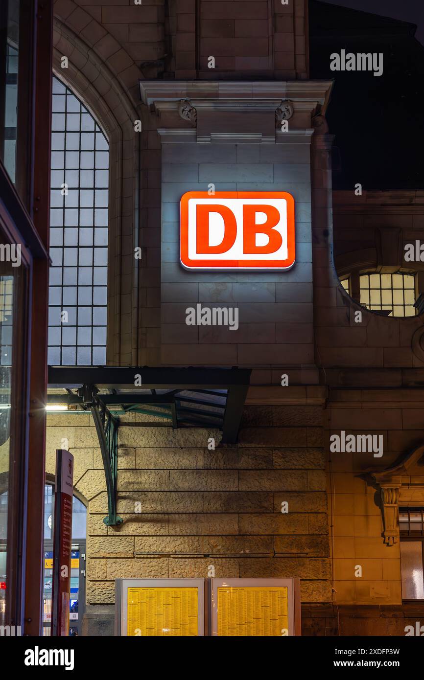 Koblenz, Deutschland - 19. Februar 2024: Auf dem Backsteinbau des Koblenzer Bahnstatios ist ein beleuchtetes DB-Schild (Deutsche Bahn) angebracht Stockfoto
