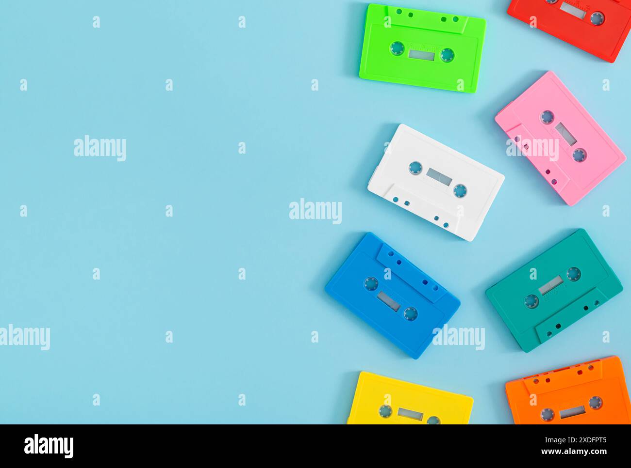 Farbenfrohes Muster aus Retro-Audiokassetten auf blauem Hintergrund mit Kopierraum. Kreatives Konzept der Retro-Technologie. Ästhetik der 80er Jahre. Stockfoto