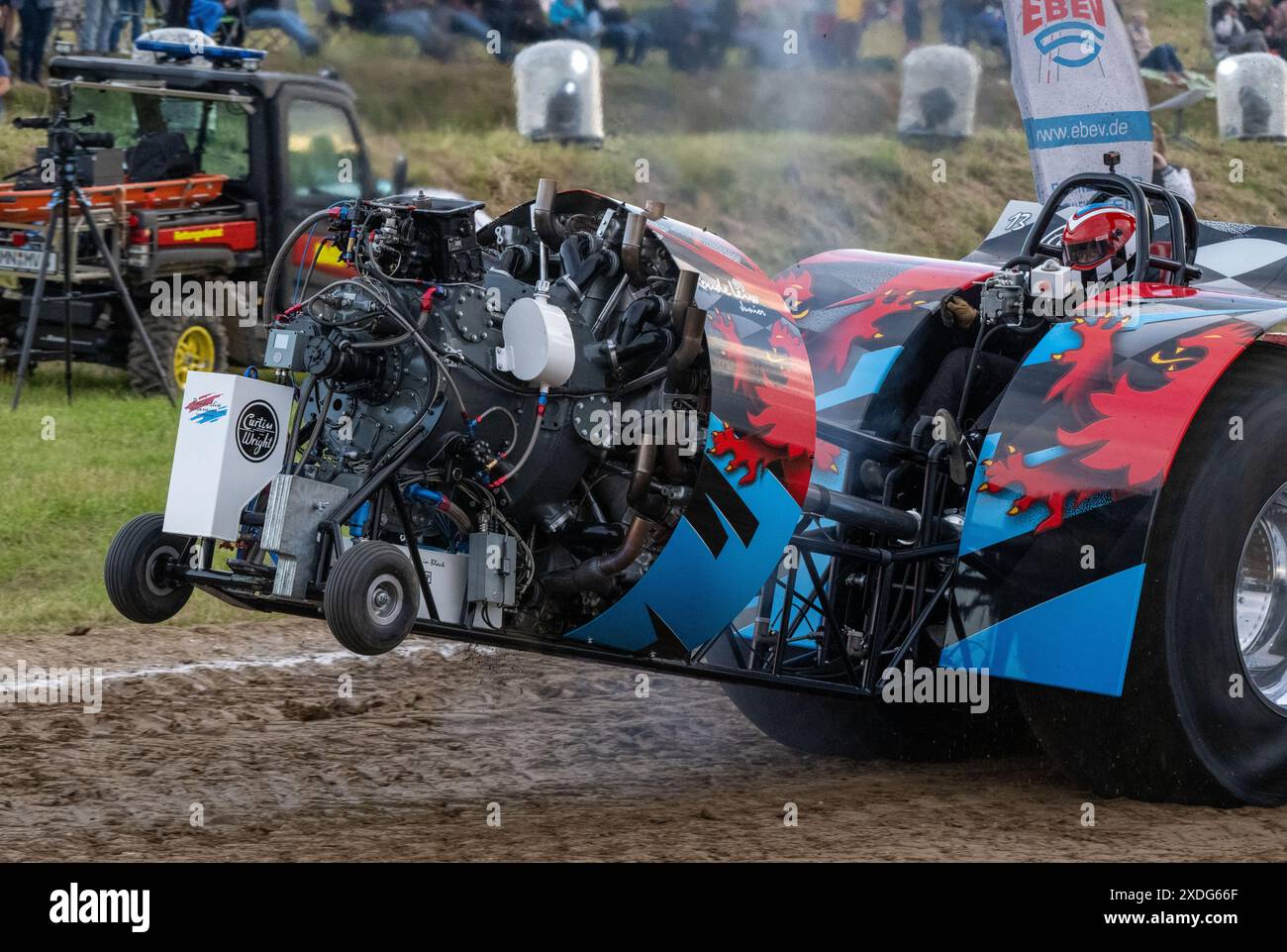 Grimmen, Deutschland. Juni 2024. Der Renntraktor „Roude Leiw“ (Luxemburg) startet im Traktorziehen über die Rennstrecke. Die Wiege dieses Sports liegt in Amerika. Die Rennen werden in verschiedenen Klassen ausgetragen. Motorleistungen von bis zu 10.000 ps machen diese übergroßen Fahrzeuge zu Riesen des Motorsports. Zum Beispiel werden Tank- und Flugzeugmotoren oder Hubschrauberturbinen zum Antrieb der Traktoren verwendet. Ziel des Wettbewerbs ist es, so schnell wie möglich einen tonnenschweren Bremsschlitten auf einer 100 m langen Strecke zu ziehen. Quelle: Stefan sauer/dpa/Alamy Live News Stockfoto