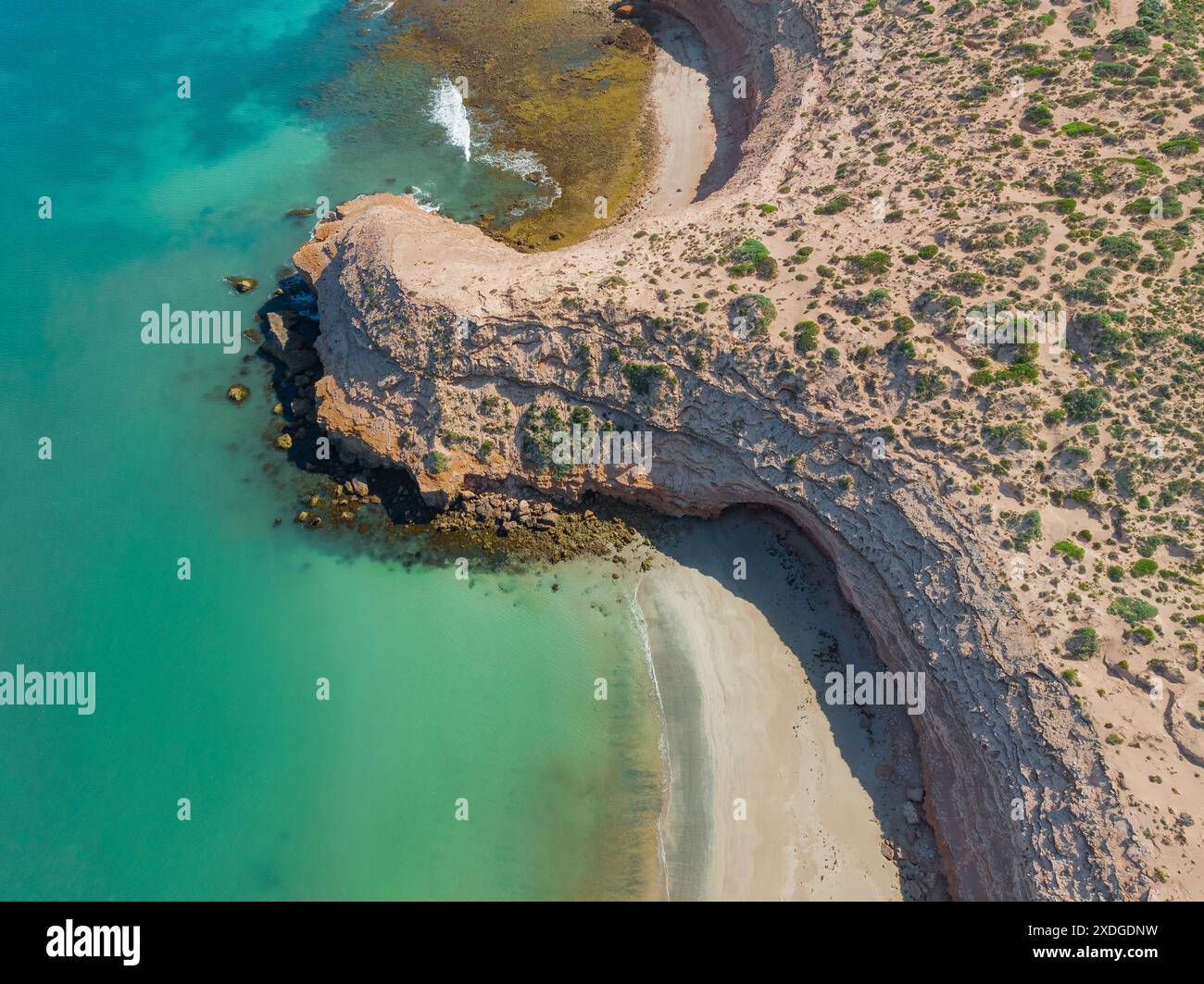 Aus der Vogelperspektive einer kargen Küstenspitze, die in eine Bucht mit ruhigem blauem Wasser an den High Cliffs auf der Eyre Peninsula in Südaustralien ragt Stockfoto