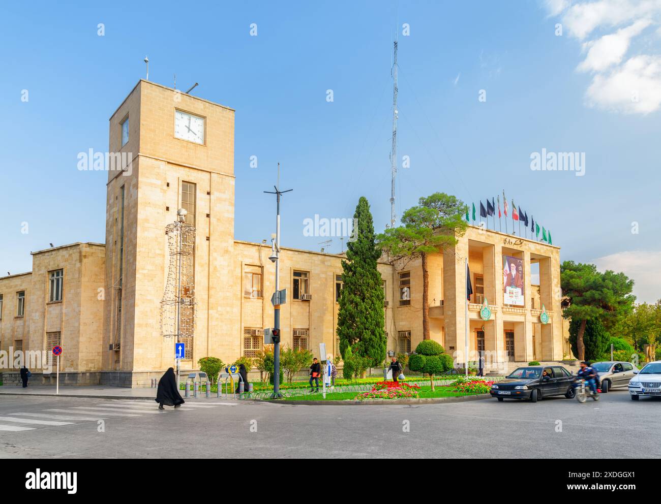 Isfahan, Iran - 22. Oktober 2018: Wunderbarer Blick auf das Rathaus von Isfahan und den malerischen Uhrturm. Die iranische Flagge flattert über dem Gebäude. Stockfoto