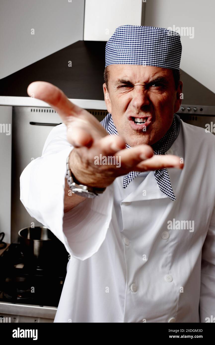 Mann, wütend und Koch mit Schreien in der Küche für Kochen, Gastfreundschaft oder kulinarischen Profi. Reifer Mensch, wütend und Lebensmittelindustrie im Hotel Stockfoto